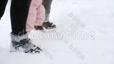 穿暖和连衣裙的婴儿脚做第一步。 孩子学会走路。 友好的全家人在冬季森林散步